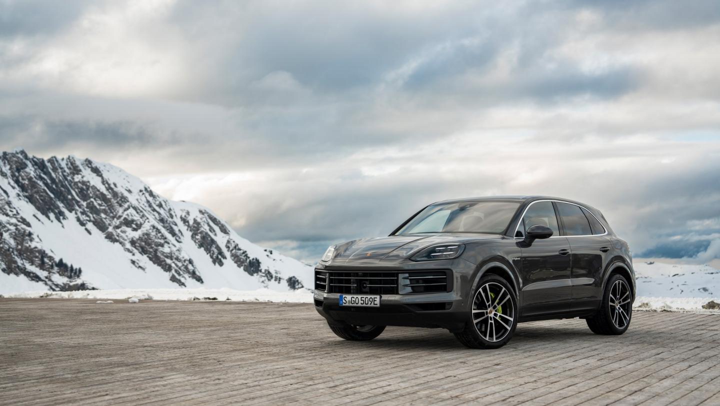 Grå Porsche Cayenne i bjerglandskab